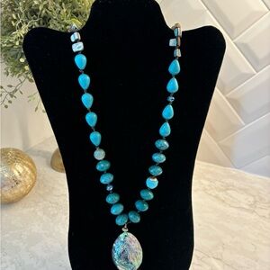 Long Chico’s turquoise colored necklace.